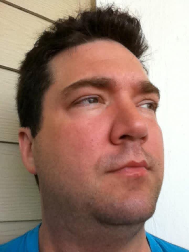 A close-up selfie of Shane outside on a bright day.