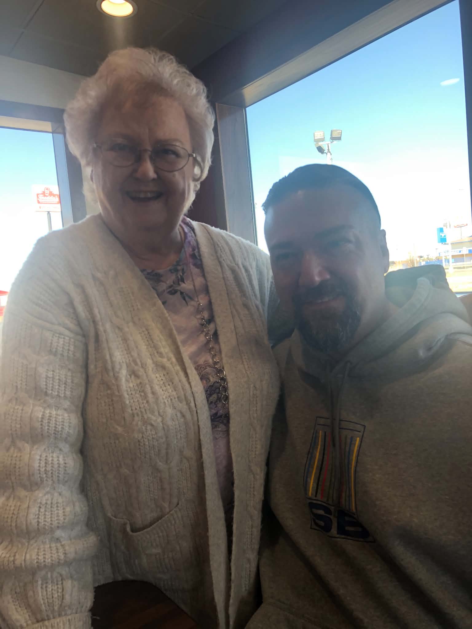 Shane with his grandmother, Sharlene, at a restaurant, both smiling.